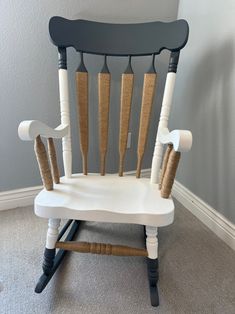 a black and white rocking chair with some wooden sticks sticking out of it's back