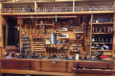 an old wooden workbench with many tools on it's shelves and drawers