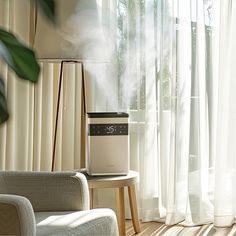 an air purifier sitting on top of a table next to a window