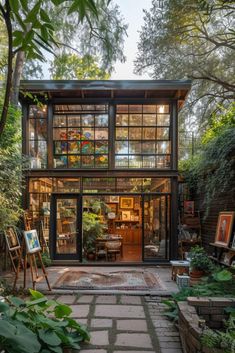 a small house with lots of windows and plants