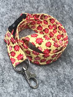 a yellow and red dog leash with hearts on it, sitting on a gray surface