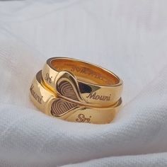 two gold wedding rings sitting on top of a white cloth with the words, i love you