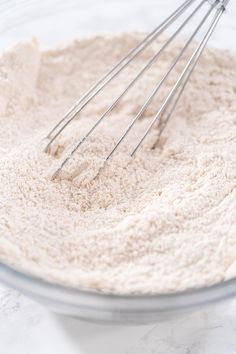 a bowl filled with flour and whisks