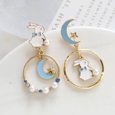 This is one of our bestsellers - how lovely it is to have a white bunny bouncing on the moon! This pair of mismatch earrings is carefully hand-painted, with decorations of faux pearl and crystal rhinestone, making it unique and pretty. * Pierced and clip-on are both now available! * Available in different colors. Sold as a pair. * Made with hypoallergic materials. * Measures 4.9cm x 2.6cm. * Please feel free to message me directly if you have any questions! Jewelry Care Instructions * Store your Unicorn Milk, Nails Grunge, Sweet Earrings, Asymmetrical Earrings, Celtic Knots, Star Earrings Stud, Milk Bottle, Moon Earrings