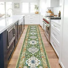 a long rug in the middle of a kitchen with white cabinets and drawers on both sides