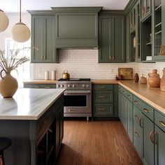 Sage green kitchens are trending, offering a calming, nature-inspired aesthetic for modern homes. Black Island Green Cabinets, Sage Green Cabinets, Green Kitchen Island, Sage Kitchen, Green Kitchen Designs, Dark Green Kitchen, Sage Green Kitchen, Green Kitchen Cabinets, Rustic Modern Kitchen