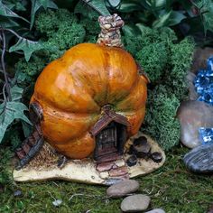 a pumpkin shaped house sitting on top of a rock