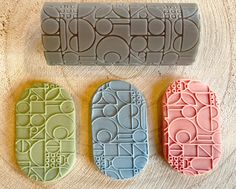 three cookie molds sitting next to each other on a wooden surface with circles and lines