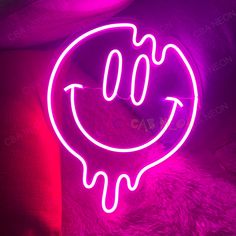 a neon sign with a smiley face on it's side in front of a couch