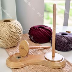 three balls of yarn sitting on top of a table next to a crochet hook