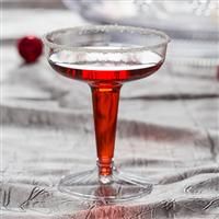 a close up of a wine glass with liquid in it on a tableclothed surface