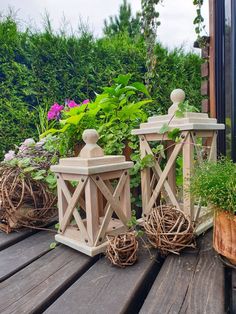 three wooden planters sitting on top of a wooden deck next to potted plants