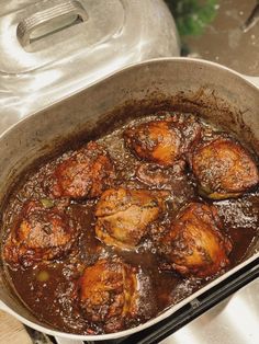 a pan filled with meat sitting on top of a stove