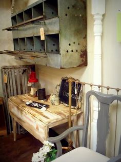 a wooden table sitting next to a chair in a room with metal shelving on the wall