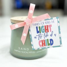 a small jar with a pink ribbon tied around it and a tag that says, thanks for being the light on the life of a child