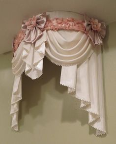 a white curtain with pink flowers hanging from it's side