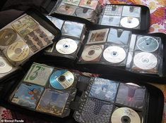 there are many cd's in the suitcases on the bed