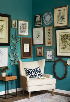 a living room with blue walls and pictures hanging on the wall, including a chair