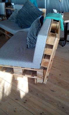 a couch made out of wooden pallets on top of a hard wood floor