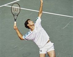 a man holding a tennis racquet on top of a tennis court