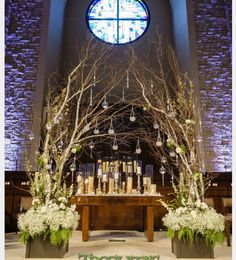 the altar is decorated with branches, flowers and candles for an elegant touch to any occasion