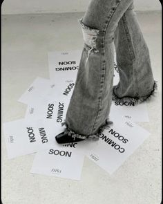 a person standing on top of some paper with words written on it and their feet in the air