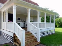 a porch with white railings and wooden steps