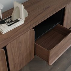 a close up of a wooden cabinet with two drawers and an electronic device on top