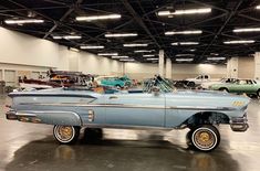 an old blue car parked in a garage