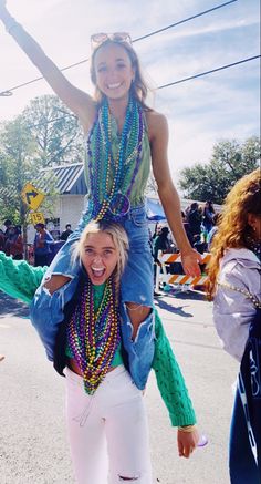 two women are riding on top of each other in the middle of a street while people watch