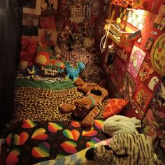 a room with stuffed animals on the bed and other stuff items in the corner around it