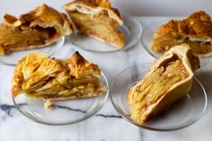 several pieces of pie sitting on top of glass plates