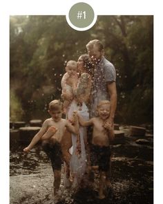 a group of people standing in the water with their arms around each other and splashing them