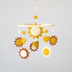 a yellow and white sun mobile hanging from the ceiling