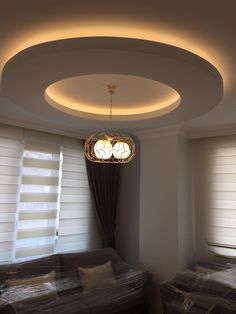 a living room with two couches and a round light fixture hanging from the ceiling