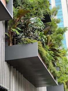 a building with plants growing on the side of it's walls and balconies