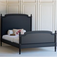 a black bed with white sheets and pillows