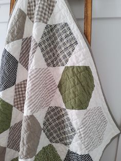 a quilt hanging on the wall next to a chair