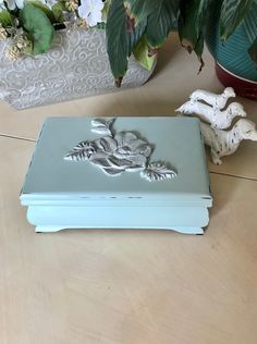 a blue box sitting on top of a wooden table next to a potted plant