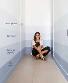 a woman sitting on the ground in front of a wall