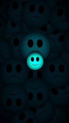 a green smiley face in the middle of a group of black balls with one light on