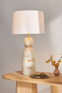 a table with a lamp and vase on it