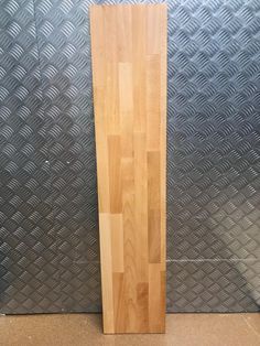 a large wooden board sitting on top of a floor next to a metal wallpaper