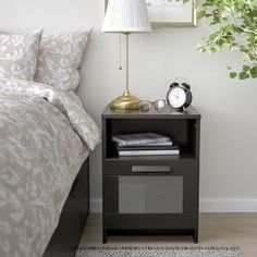 a bedroom with a bed, nightstand and mirror