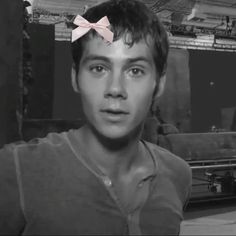 a man with a pink bow on his head in a black and white photo is looking at the camera