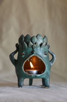 a tea light holder shaped like a monster