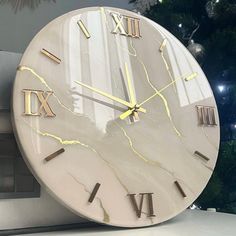 a white clock sitting on top of a counter next to a christmas tree