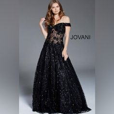 Make A Statement At Your Next Formal Event In This Breathtaking Jovani Gown. This Show-Stopping Black Dress Exudes Glamour And Sophistication With Its Intricate Design And Alluring Silhouette. The Bodice Features A Daring Off-The-Shoulder Neckline, Accentuating The Dcolletage With Elegance. A Stunning Sheer Corset-Style Midsection Adorned With Delicate Embroidery And Sequins Creates A Captivating Focal Point, Offering A Tasteful Glimpse Of Skin While Maintaining An Air Of Mystery. The Gown's Ful Black Gown With Fitted Bodice For Evening, Glamorous Black Gala Gown, Black Gala Dress With Sweetheart Neckline, Glamorous Black Ball Gown Dress, Black Ball Gown For Evening, Black Evening Ball Gown, Black Evening Gown With Sweetheart Neckline, Black Sweetheart Neckline Evening Gown, Black Gown With Sweetheart Neckline For Evening