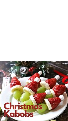 christmas kabobs on a white plate with green grapes and strawberries in the middle