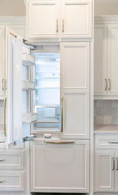 a white refrigerator freezer sitting inside of a kitchen next to wooden floors and cabinets